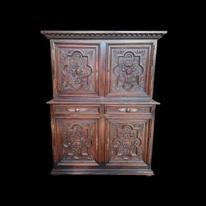 A solid oak 4-door cabinet with richly carved panels.